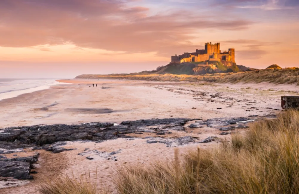 Bamburgh Castle on the Northumberland coastline, bathed in late afternoon golden sunlight